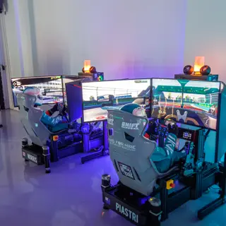 Two SimsForHire full-motion simulators with race-suited drivers racing side by side