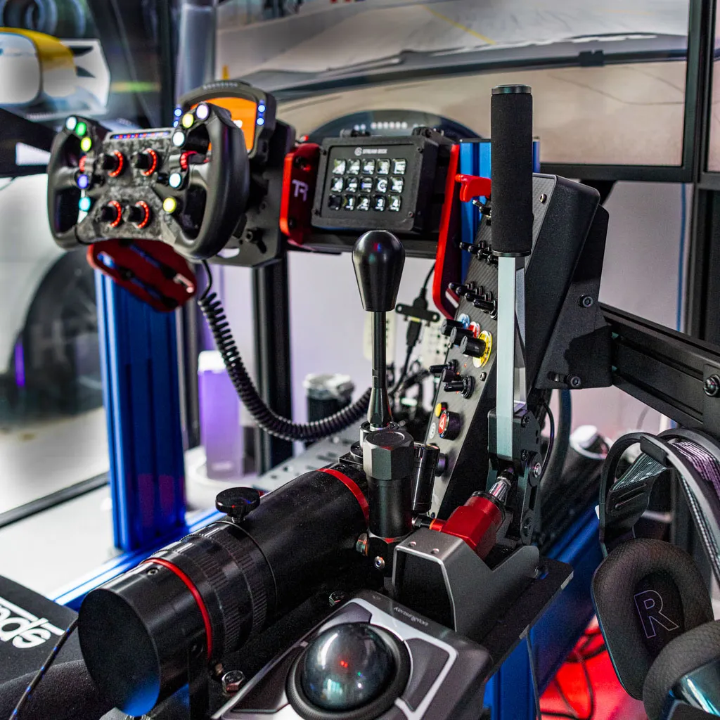 Close-up of a simulator cockpit: wheel, shifter and handbrake