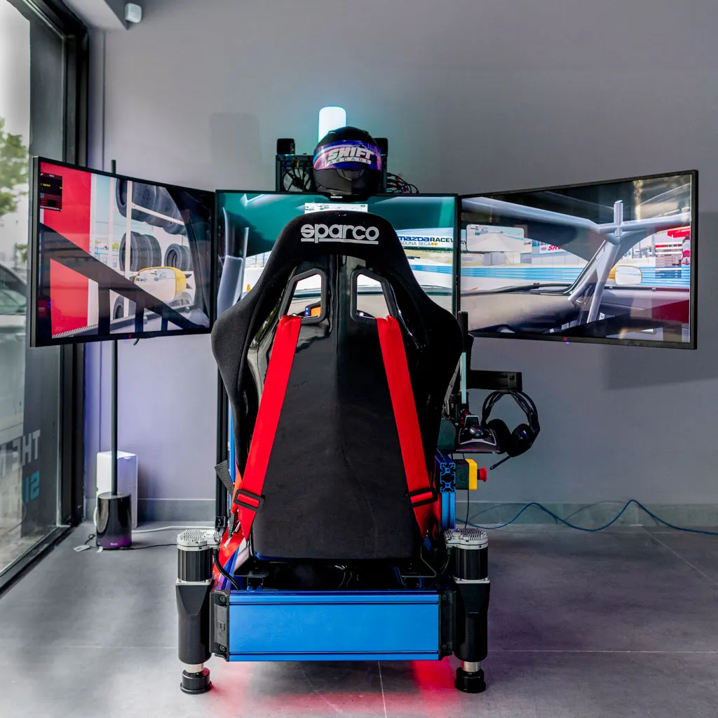 Racing simulator seen from behind the seat, three screens ahead